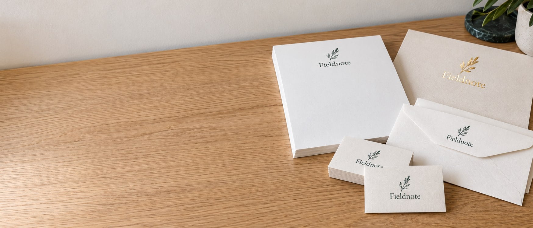Custom letterhead and envelopes with one brand name on a light oak desk